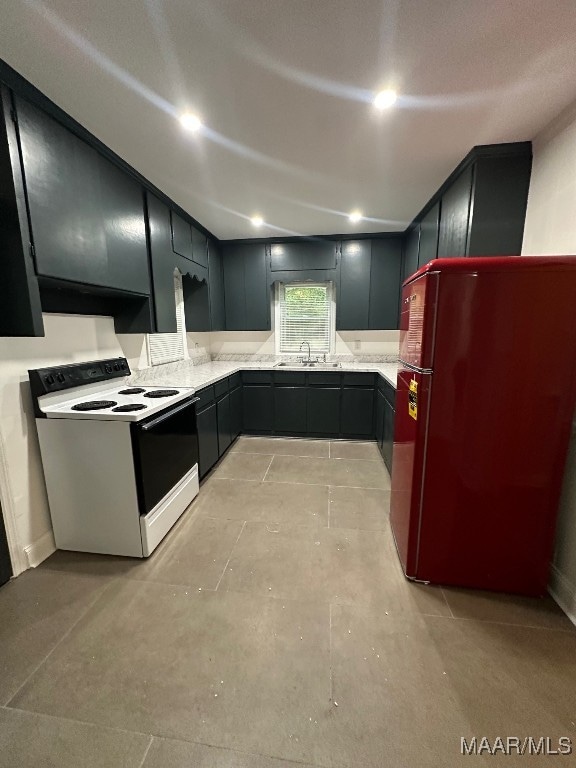 kitchen featuring sink, refrigerator, and white range with electric cooktop