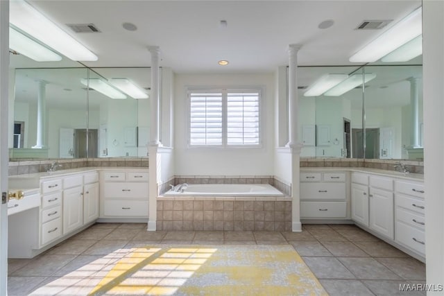 bathroom featuring ornate columns, vanity, tile patterned flooring, and a relaxing tiled tub