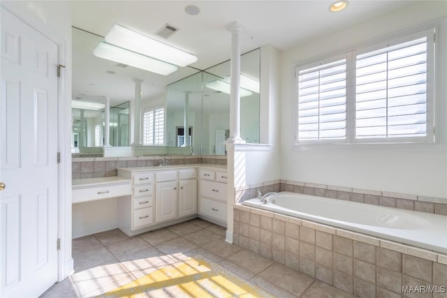 bathroom with tile patterned flooring, decorative columns, and a wealth of natural light