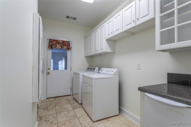 clothes washing area with cabinets and independent washer and dryer