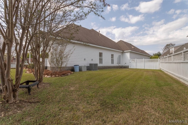 rear view of property with cooling unit and a yard