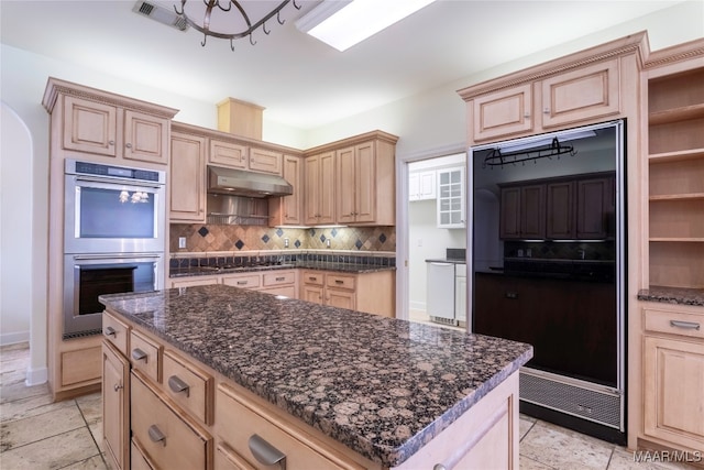 kitchen featuring fridge, light brown cabinetry, and double oven