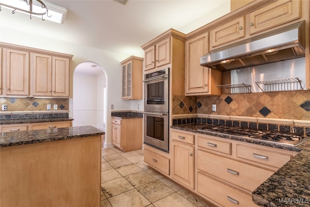 kitchen with tasteful backsplash, dark stone countertops, appliances with stainless steel finishes, and light brown cabinets