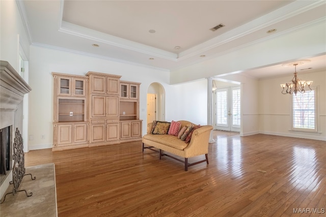 sitting room with a raised ceiling, plenty of natural light, hardwood / wood-style flooring, and a fireplace