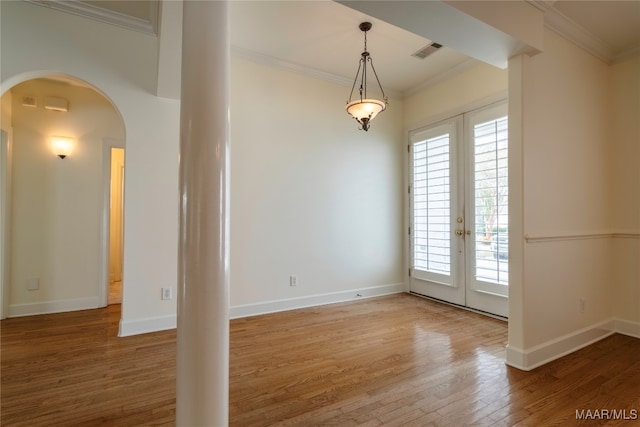 unfurnished room with crown molding, hardwood / wood-style floors, and french doors