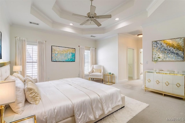 carpeted bedroom with crown molding, ceiling fan, and a tray ceiling