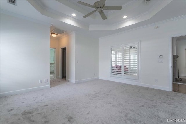 carpeted empty room featuring crown molding, ceiling fan, and a tray ceiling