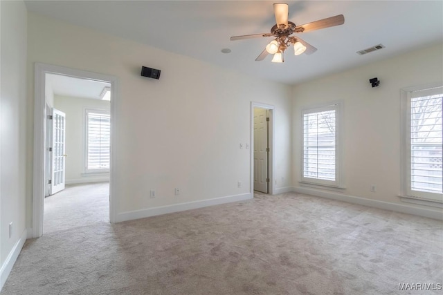 carpeted empty room featuring ceiling fan and a healthy amount of sunlight