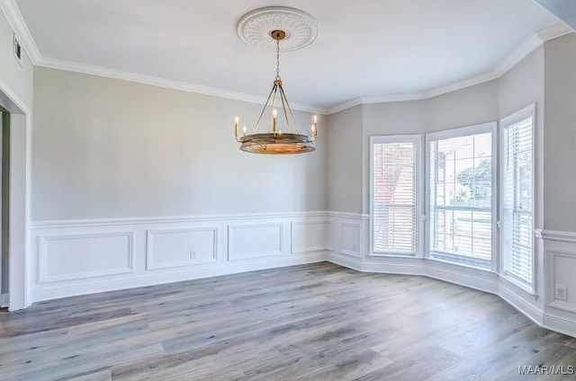 200 Mcrae Rd, Deatsville, AL 36022 - unfurnished dining area with a chandelier, light wood-type flooring, crown molding, wainscoting, and a decorative wall