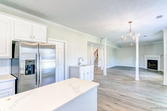 kitchen with decorative backsplash, stainless steel fridge with ice dispenser, pendant lighting, and white cabinetry