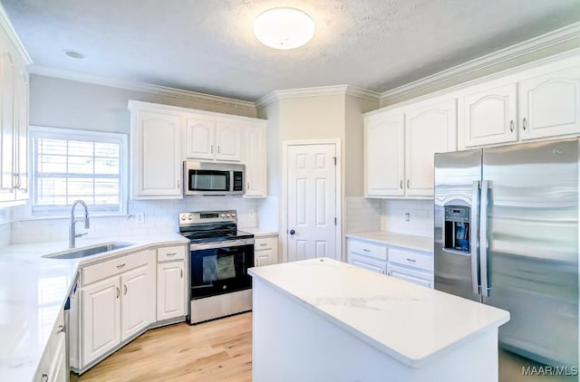 200 Mcrae Rd, Deatsville, AL 36022 - kitchen with appliances with stainless steel finishes, a sink, white cabinets, a center island, and ornamental molding