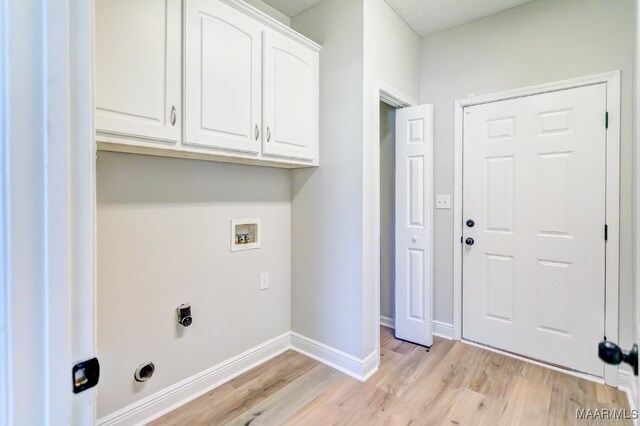 clothes washing area featuring hookup for a washing machine, cabinets, light hardwood / wood-style flooring, and hookup for an electric dryer