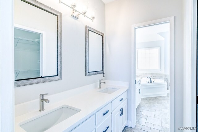 bathroom featuring vanity, a tub, and tile patterned flooring