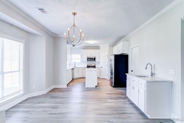 200 Mcrae Rd, Deatsville, AL 36022 - kitchen with appliances with stainless steel finishes, a chandelier, a sink, light wood finished floors, and white cabinets