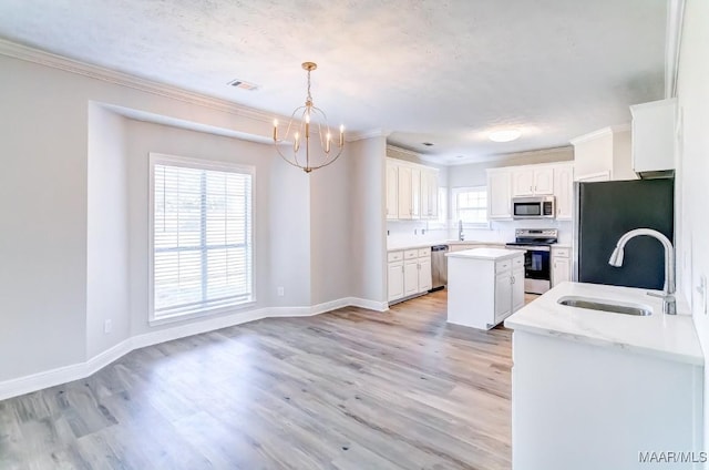 200 Mcrae Rd, Deatsville, AL 36022 - kitchen with stainless steel appliances, a sink, a chandelier, crown molding, and white cabinetry
