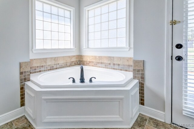 bathroom featuring a bath and a wealth of natural light