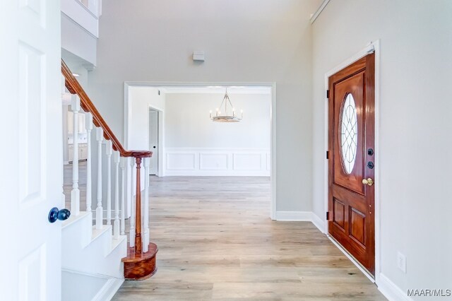 foyer entrance featuring an inviting chandelier and light wood-type flooring