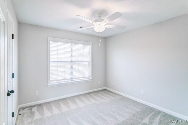 unfurnished room featuring light colored carpet and ceiling fan