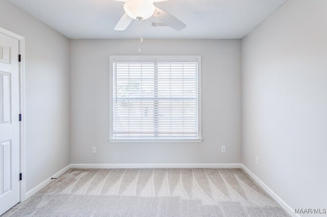 carpeted spare room featuring ceiling fan