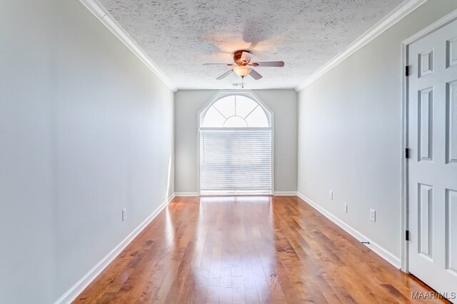 unfurnished room with crown molding, a textured ceiling, light wood-type flooring, and ceiling fan