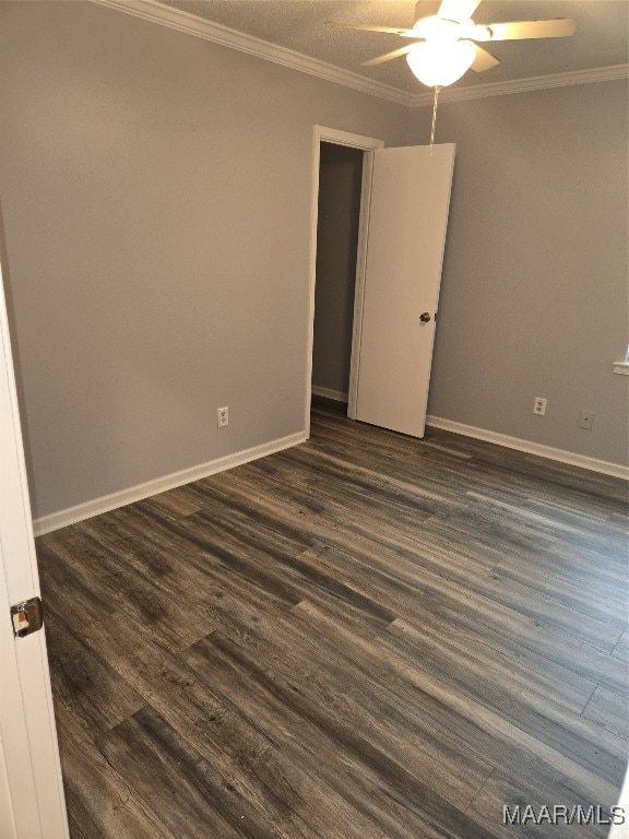 empty room featuring ceiling fan, ornamental molding, and dark hardwood / wood-style flooring