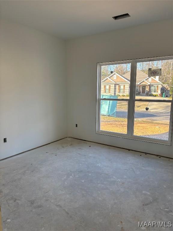 unfurnished room featuring unfinished concrete flooring and visible vents