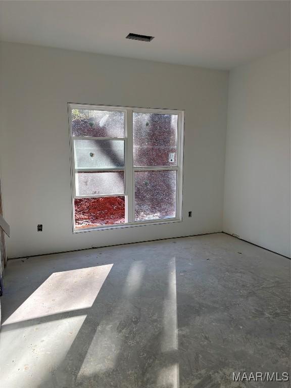 spare room with plenty of natural light and concrete flooring