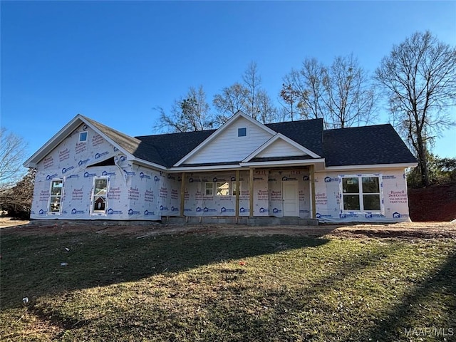 unfinished property featuring a porch and a front lawn