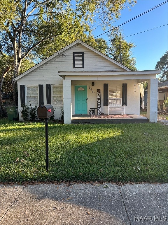 view of front of house with a porch and a front lawn