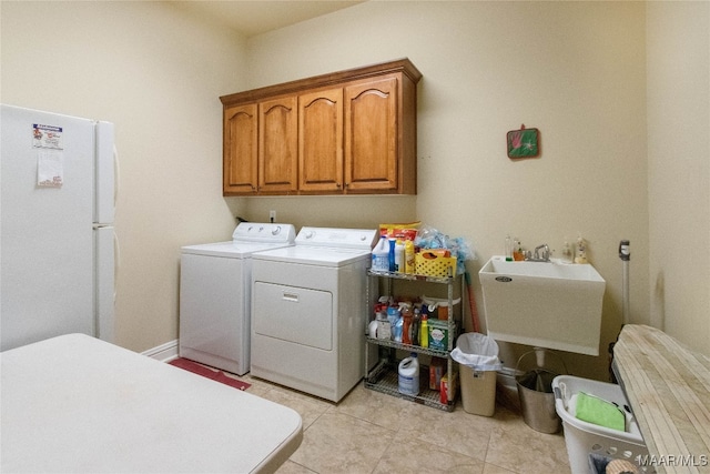 washroom featuring sink, independent washer and dryer, cabinets, and light tile patterned floors