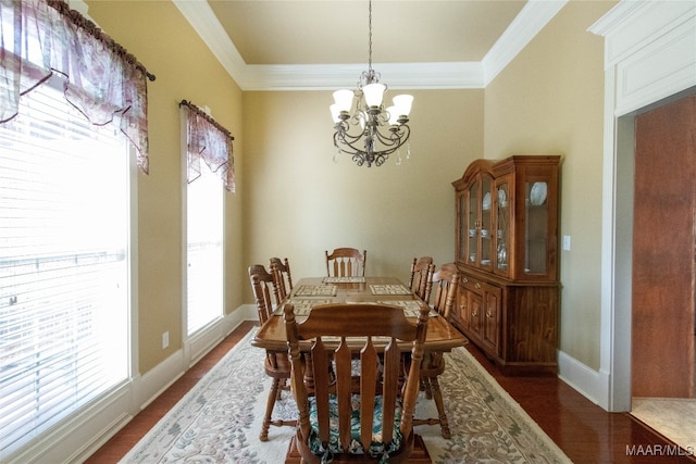 dining space featuring ornamental molding, an inviting chandelier, and dark hardwood / wood-style floors