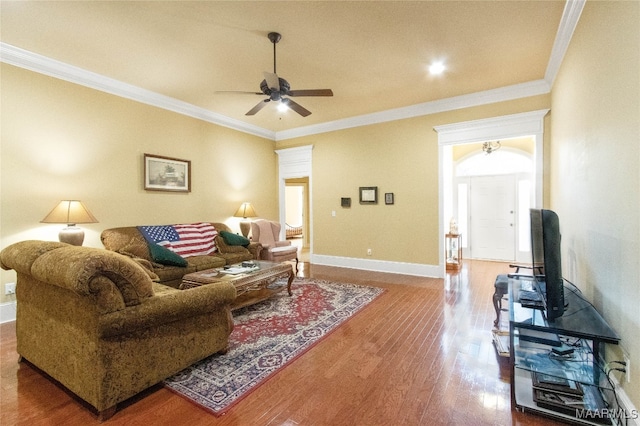 living room with crown molding, wood-type flooring, and ceiling fan