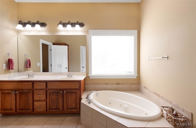 bathroom featuring vanity, a relaxing tiled tub, and tile patterned floors