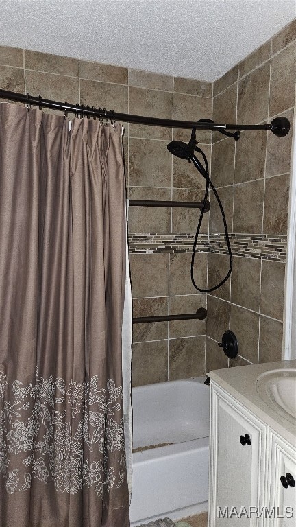 bathroom with vanity, a textured ceiling, and shower / bathtub combination with curtain