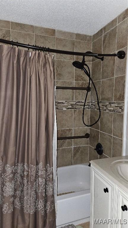 bathroom featuring vanity, shower / tub combo, and a textured ceiling