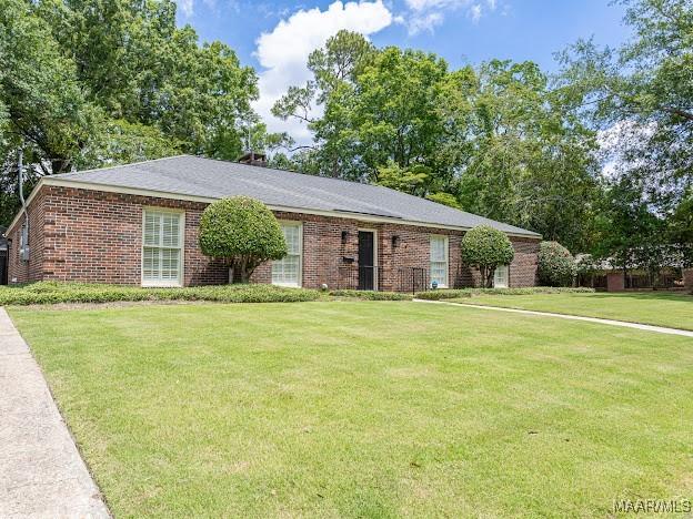 ranch-style home featuring a front lawn and brick siding