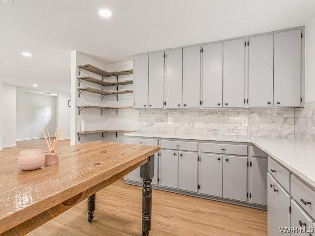 kitchen with tasteful backsplash, gray cabinetry, light wood-type flooring, and recessed lighting
