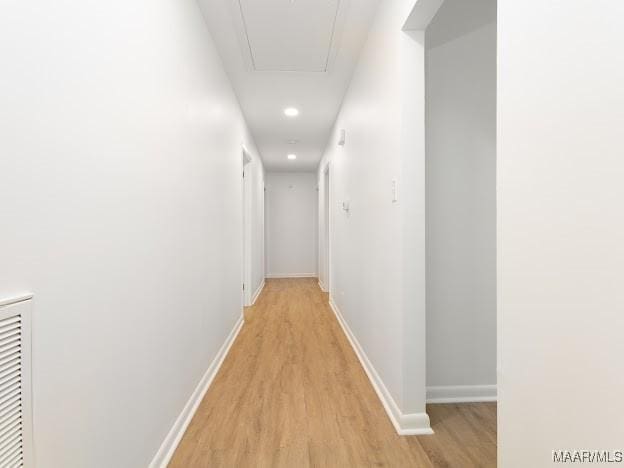 corridor with attic access, recessed lighting, visible vents, light wood-style flooring, and baseboards