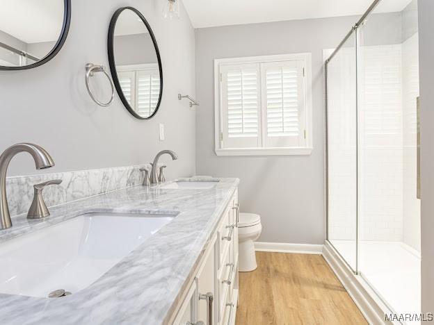 bathroom featuring a sink, a shower stall, and wood finished floors