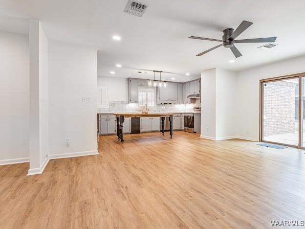 unfurnished living room featuring visible vents, ceiling fan, light wood-style flooring, and baseboards