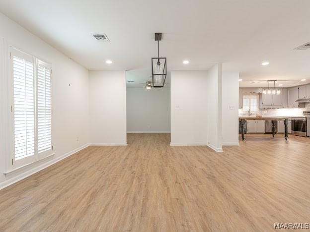 interior space with light wood finished floors, recessed lighting, visible vents, and baseboards