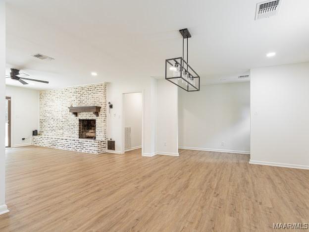 unfurnished living room with visible vents, ceiling fan, baseboards, and light wood-style floors