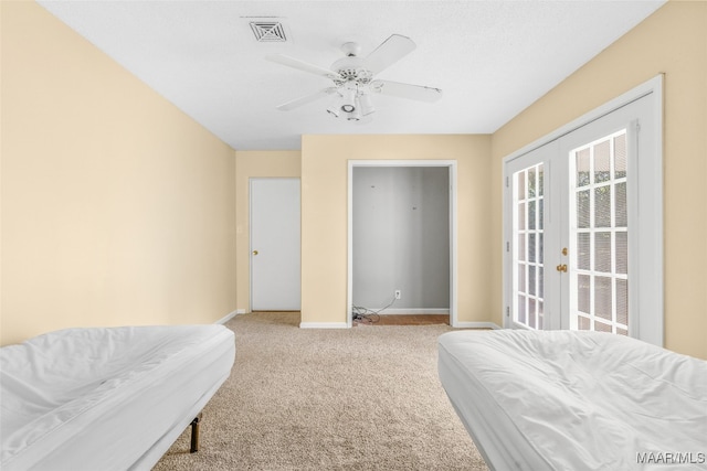 carpeted bedroom with french doors and ceiling fan