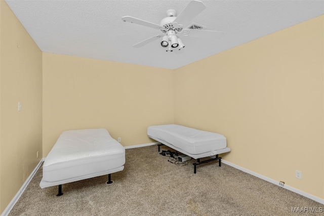 living area featuring light carpet, a textured ceiling, and ceiling fan