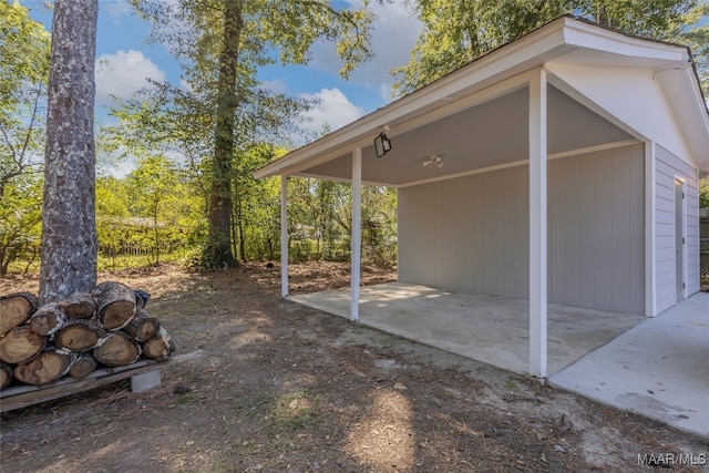 view of patio / terrace with a carport, a garage, and an outdoor structure