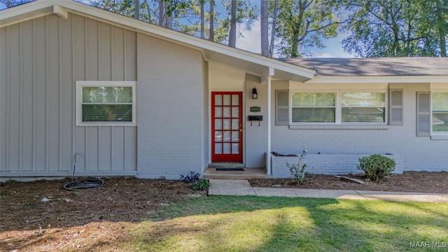 view of exterior entry featuring a yard