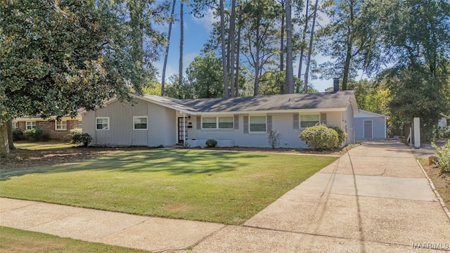 ranch-style house with a front yard, a garage, and an outbuilding