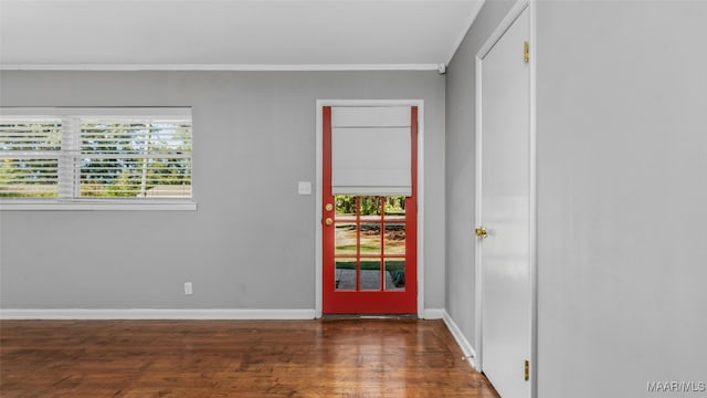 unfurnished room featuring crown molding, a wealth of natural light, and dark hardwood / wood-style flooring