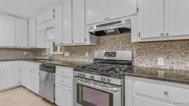 kitchen with sink, white cabinets, stainless steel appliances, and dark stone counters