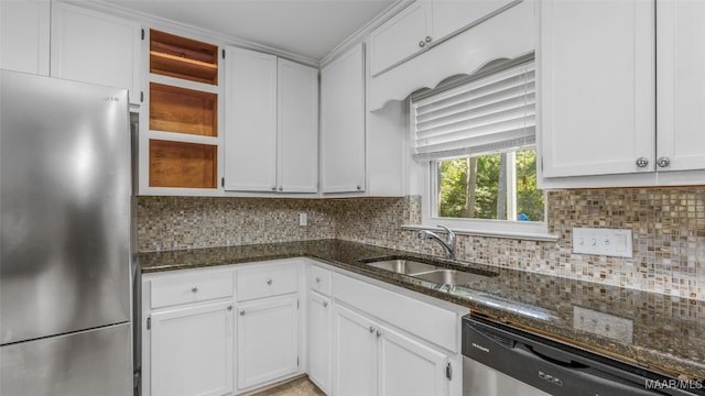 kitchen featuring dark stone counters, sink, white cabinets, appliances with stainless steel finishes, and tasteful backsplash